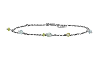 Silverarmband med ljusblå och gröna pärlor, hummerklämma och mönstrad charm nära klämman.