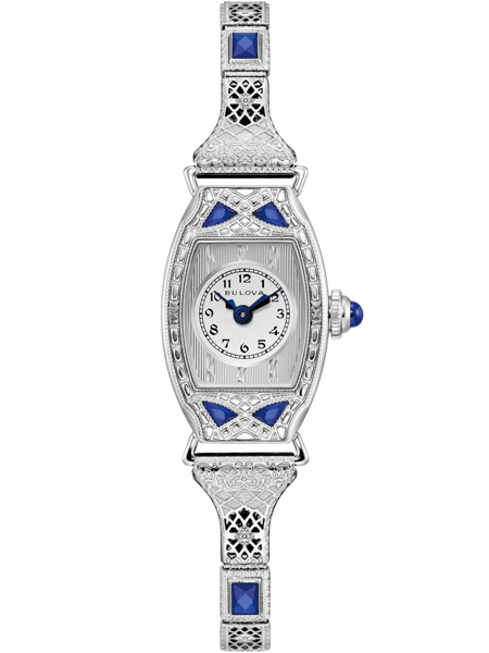 Oval urtavla med mönster, blå accenter och intrikata detaljer på boett och band.